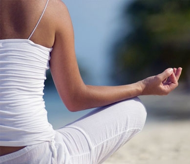 Female meditating at the beach to find her happy new you.